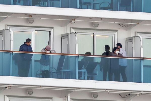 Пассажиры на палубе круизного судна Diamond Princess в порту Йокогамы