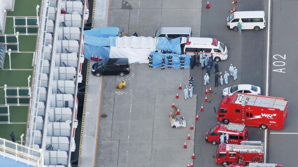 Скорая помощь забирает в больницу людей с круизного лайнера Diamond Princess в порту Йокогамы