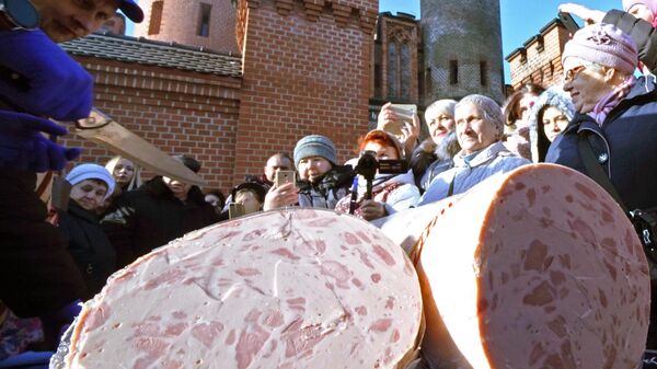 Презентация стокилограммового трехметрового батона колбасы, изготовленного на Гвардейском мясокомбинате  на празднике День длинной колбасы в Калининграде