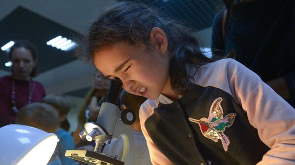 Девочка рассматривает материал под микроскопом