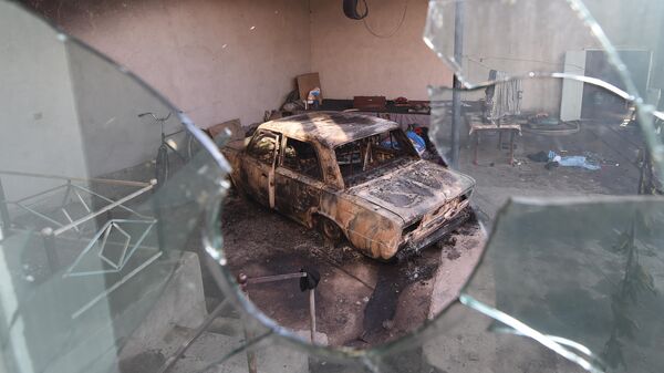 Сгоревшая машина  в селе Блас-Батыр, в 250 км от Алматы, где прошли бесполрядки