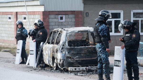 Сотрудники полиции у сгоревшего автомобиля на улице поселка Масанчи