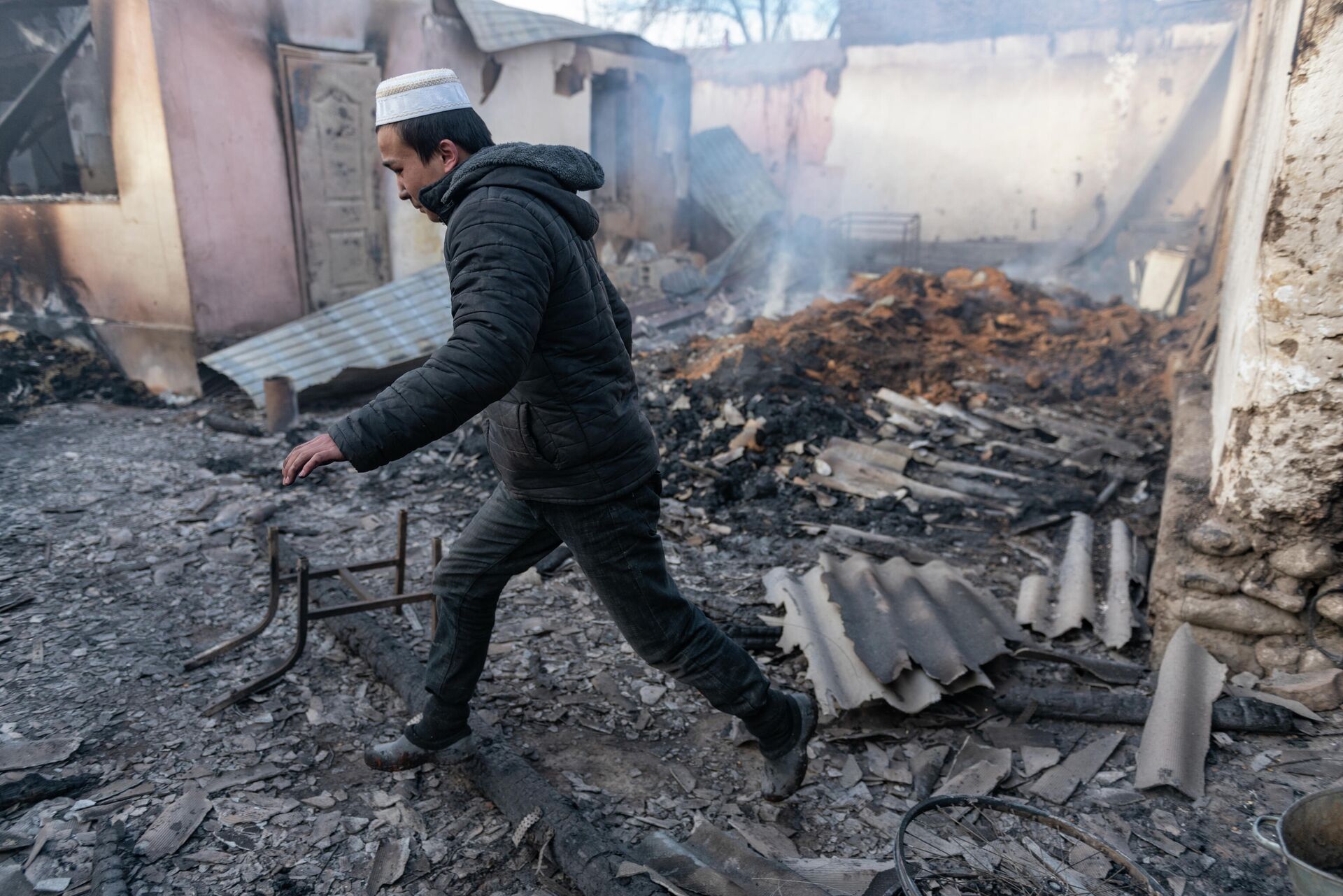 Мужчина проходит у сгоревшего здания в поселке Масанчи - РИА Новости, 1920, 13.08.2021