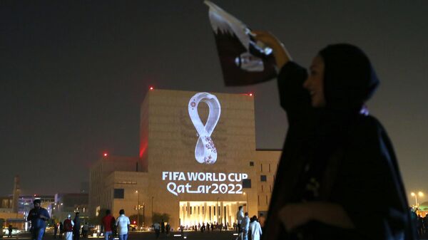 A woman cheers as Qataris gather at the capital Doha's traditional Souq Waqif market to see the official logo of the FIFA World Cup Qatar 2022 projected on the front of a building on September 3, 2019. (Photo by - / AFP)