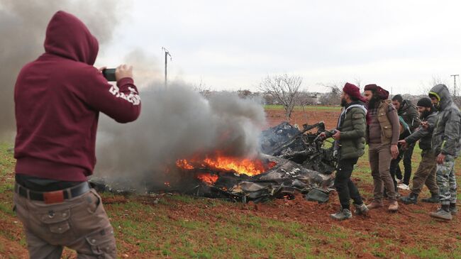 Горящие обломки военного вертолета примерно в 6 километрах к юго-востоку от города Идлиб. 11 февраля 2020