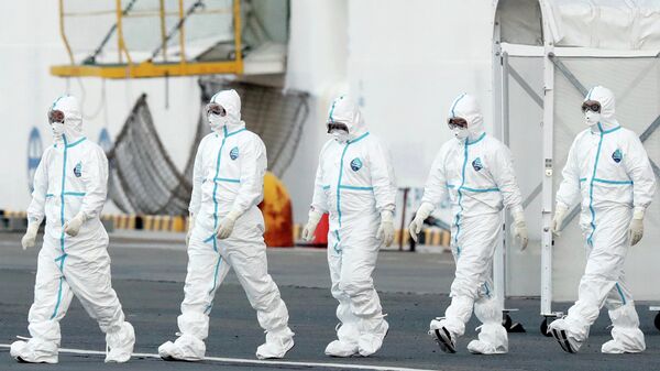 Персонал в защитных костюмах у круизного судна Diamond Princess в порту Йокогамы