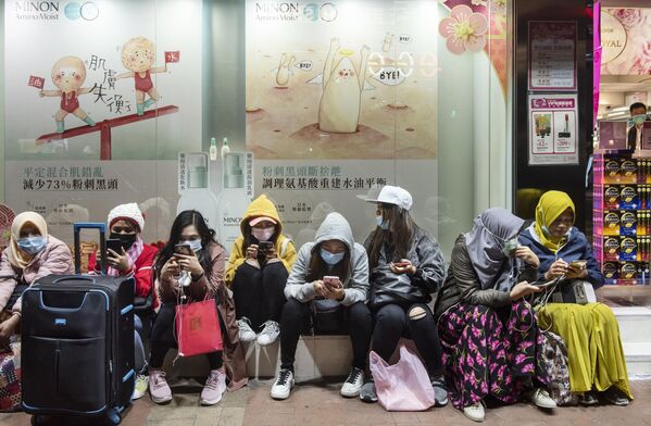 Женщины в защитных масках на одной из улиц в Гонконге