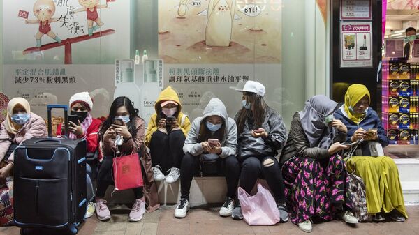 Женщины в защитных масках на одной из улиц в Гонконге