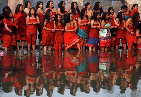 Женщины стоя на берегу реки Хануманте в Бхактапуре, Непал