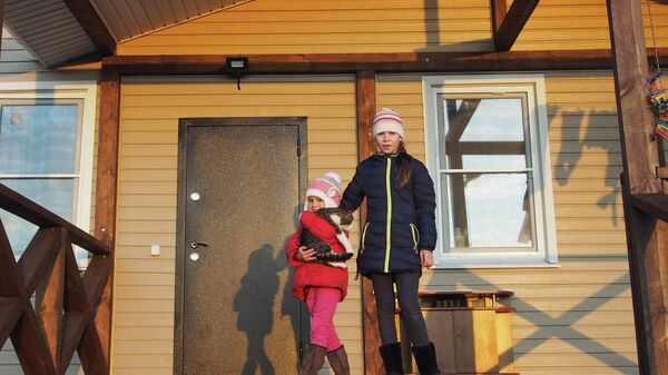 Дочери Екатерины и Алексея Богачевых на крыльце нового дома с котом