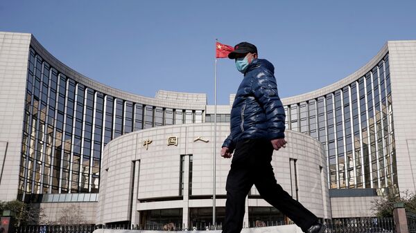 Мужчина в защитной маске проходит мимо штаб-квартиры Народного банка Китая в Пекине