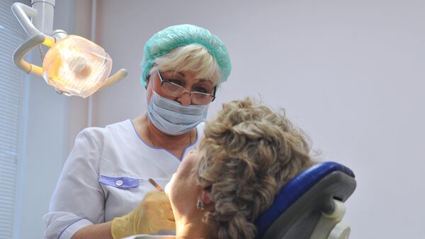Врач-стоматолог во время приема пациента в городской стоматологической поликлинике