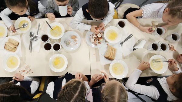 Ученики школы обедают в столовой