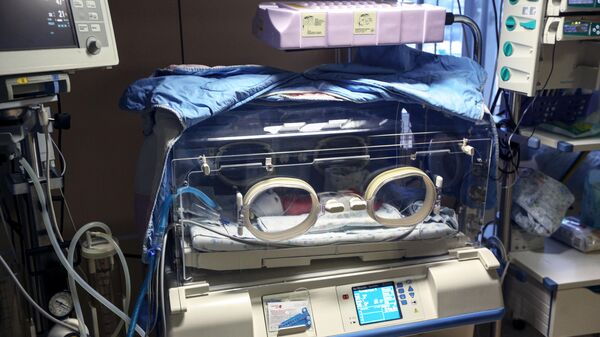 Младенец в кувезе в отделении реанимации и интенсивной терапии новорожденных 