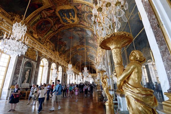Посетители в Зеркальной галерее Версальского дворца в Париже