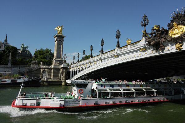 Туристический теплоход проходит под мостом Александра III в Париже