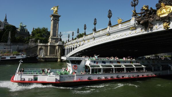 Туристический теплоход проходит под мостом Александра III в Париже