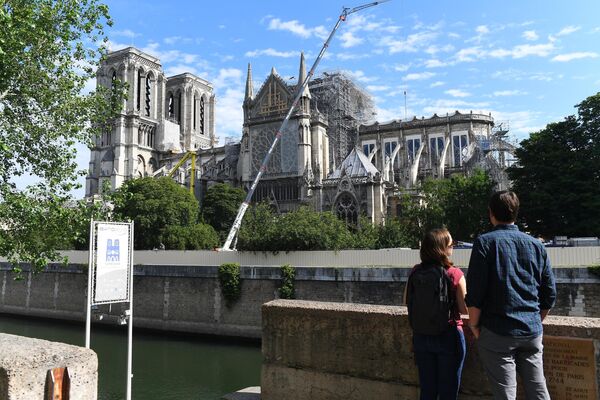 Туристы на набережной Сены у Собора Парижской Богоматери в Париже
