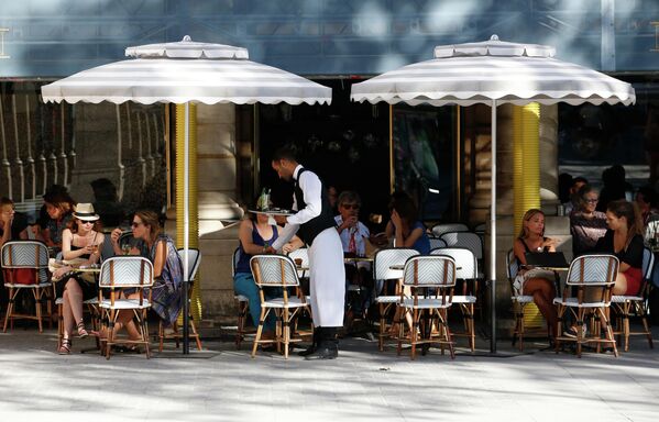 Посетители на летней веранде кафе возле Пале-Рояль в Париже