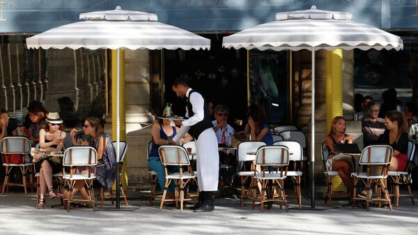 Посетители на летней веранде кафе возле Пале-Рояль в Париже