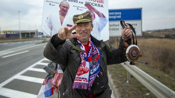 Житель Сербии Милован Милутинович несет ракию для Путина