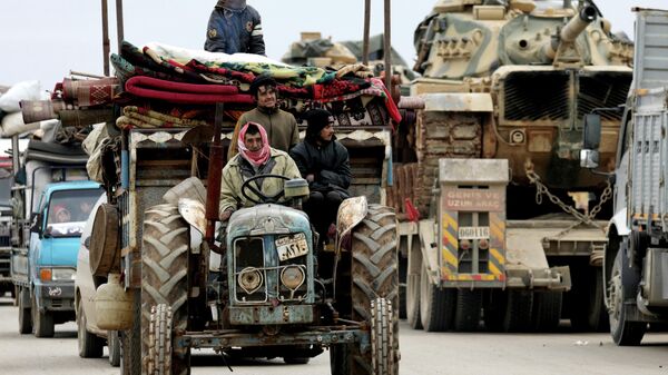 Покинувшие свои дома сирийцы и колонна турецкой военной техники в Хазано, недалеко от Идлиба