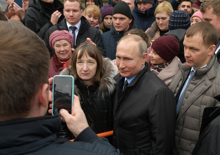 Президент РФ Владимир Путин фотографируется с жителями города после церемонии возложения цветов к памятнику первому мэру Санкт-Петербурга Анатолию Собчаку