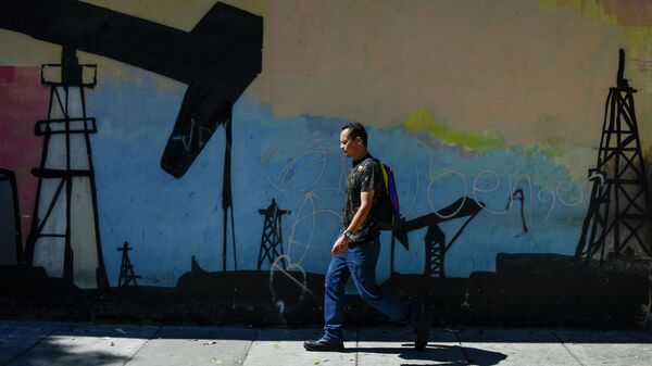 Мужчина проходит мимо граффити с изображением нефтяной вышки в Каракасе, Венесуэла 