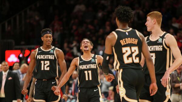 Feb 20, 2020; Atlanta, Georgia, USA; Atlanta Hawks guard Trae Young (11) celebrates with forward De'Andre Hunter (12) and guard Kevin Huerter (3) after a basket by guard Cam Reddish (22) against the Miami Heat in the second half at State Farm Arena. Mandatory Credit: Brett Davis-USA TODAY Sports