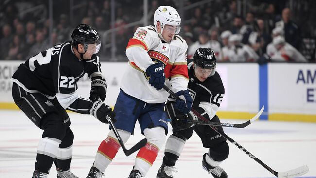 LOS ANGELES, CALIFORNIA - FEBRUARY 20: Frank Vatrano #77 of the Florida Panthers splits the defense of Trevor Lewis #22 and Trevor Moore #12 of the Los Angeles Kings during the first period at Staples Center on February 20, 2020 in Los Angeles, California.   Harry How/Getty Images/AFP