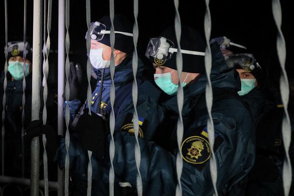 Военнослужащие Национальной гвардии Украины блокируют ворота медицинского учреждения, где планируется держать эвакуированных из Китая