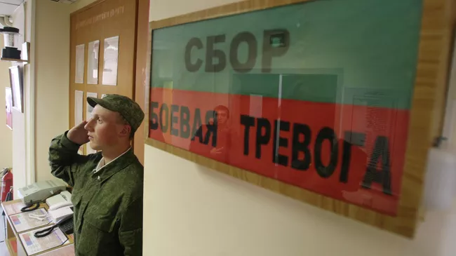 Военнослужащий отдает честь у входа в казарму общевойсковой отдельной мотострелковой бригады Западного военного округа, дислоцированной в поселке Каменка Ленинградской области.