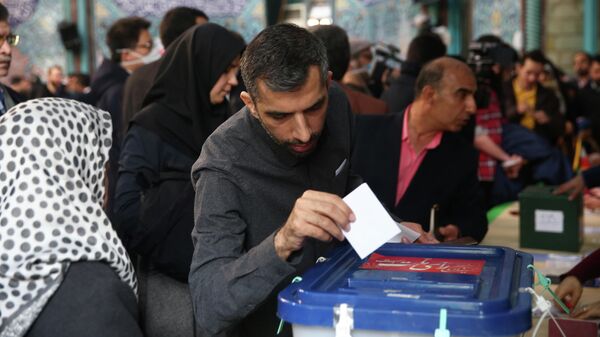 Мужчина во время голосования на парламентских выборов в Тегеране