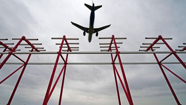 Самолет пролетает над курсовым радиомаяком системы посадки в аэропорту
