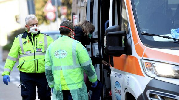 Автомобиль скорой помощи и медицинские работники в итальянском городе Казальпустерленго