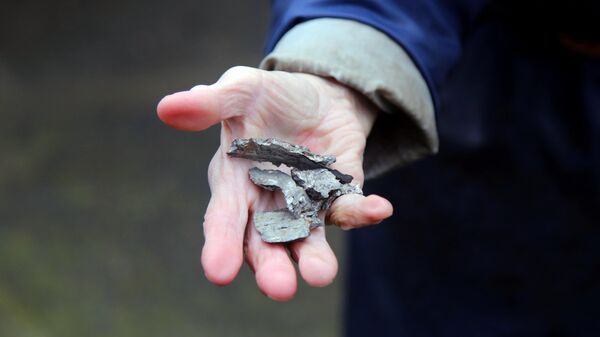 Фрагмент снаряда, найденный на месте артобстрела в поселке Гольмовский, в Донецкой области