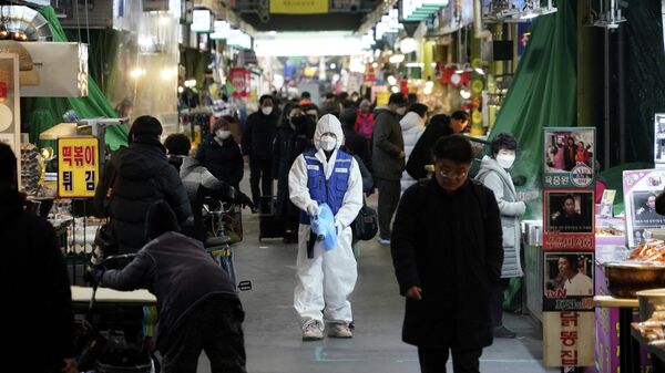 Сотрудник компании, занимающейся дезинфекцией, очищает пол на рынке в Сеуле, Южная Корея. 24 февраля 2020 