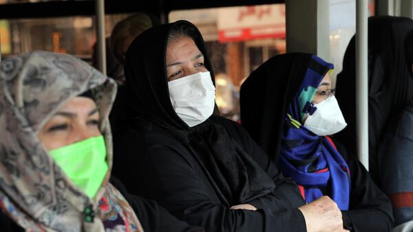 Пассажиры в масках для защиты от коронавируса в общественном автобусе в центре Тегерана, Иран 