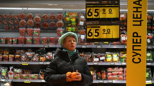 Женщина выбирает апельсины в супермаркете Перекресток в Москве