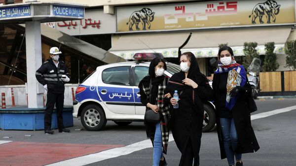 Люди в защитных масках на улице в Тегеране, Иран. 23 февраля 2020