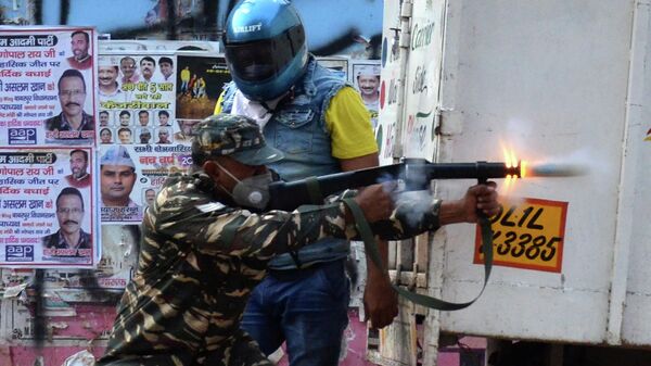 Полицейский во время столкновений в Нью-Дели