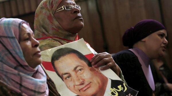 Сторонница бывшего президента Египта Хосни Мубарака держат его фотографию