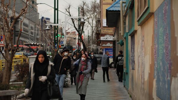 Люди в медицинских масках на улице  Тегерана