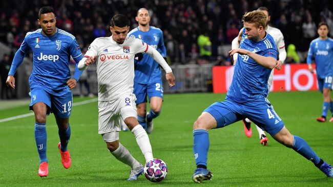 Lyon's French midfielder Houssem Aouar (C) is challenged by Juventus' Brazilian defender Alex Sandro (L) and de Juventus' Dutch defender Matthijs de Ligt during the UEFA Champions League round of 16 first-leg football match between Lyon and Juventus at the Parc Olympique Lyonnais stadium in Decines-Charpieu, central-eastern France, on February 26, 2020. (Photo by Philippe DESMAZES / AFP)