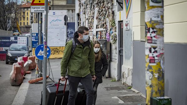 Туристы в масках на одной из улиц в Италии