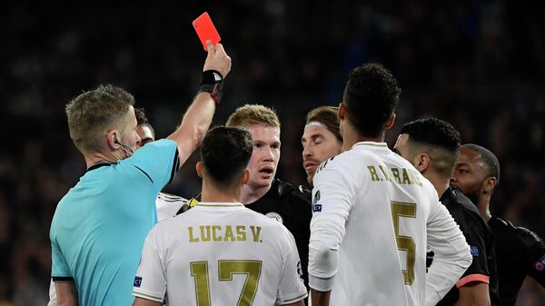 Real Madrid's Spanish defender Sergio Ramos (C) is handed a red card by Italian referee Daniele Orsato during the UEFA Champions League round of 16 first-leg football match between Real Madrid CF and Manchester City at the Santiago Bernabeu stadium in Madrid on February 26, 2020. (Photo by JAVIER SORIANO / AFP)