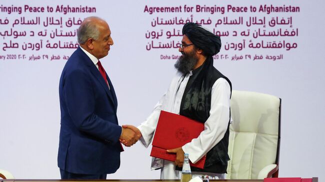 Мулла Абдул Гани Барадар, глава делегации талибов, и Залмай Халилзад, посланник США по вопросам мира в Афганистане, после подписания соглашения в Дохе, Катар. 29 февраля 2020