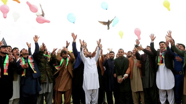 Афганские мужчины празднуют заключение соглашения между США и движением Талибан