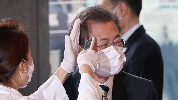 Медицинский работник измеряет температуру президенту Южной Кореи Мун Чжэ Ину, прибывшему на Национальную ассамблею в Сеул 