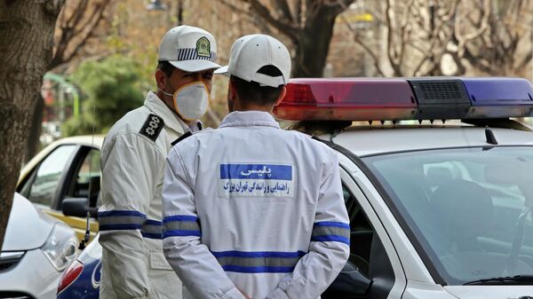 Сотрудники спасательной службы в защитных масках в Тегеране